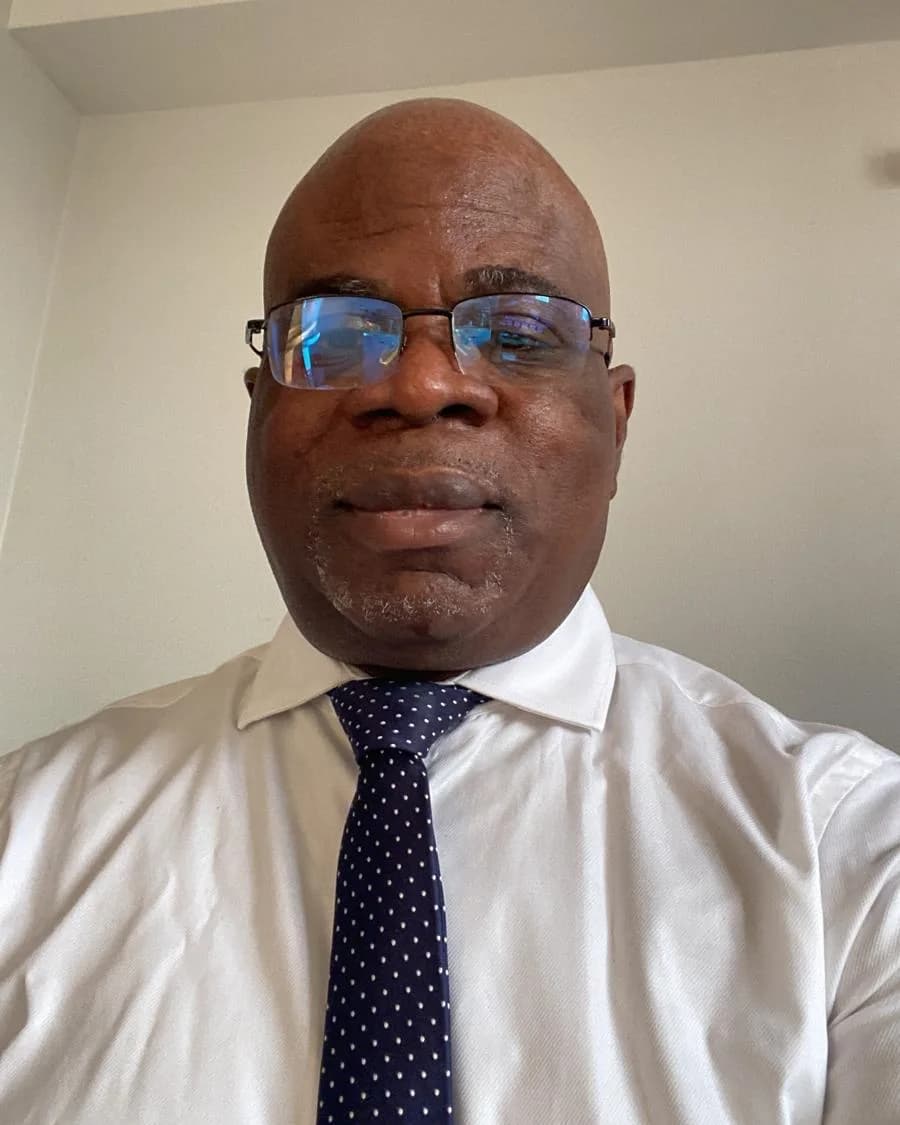 Danh Tehe Amos in glasses, a white shirt and a navy polka-dot tie